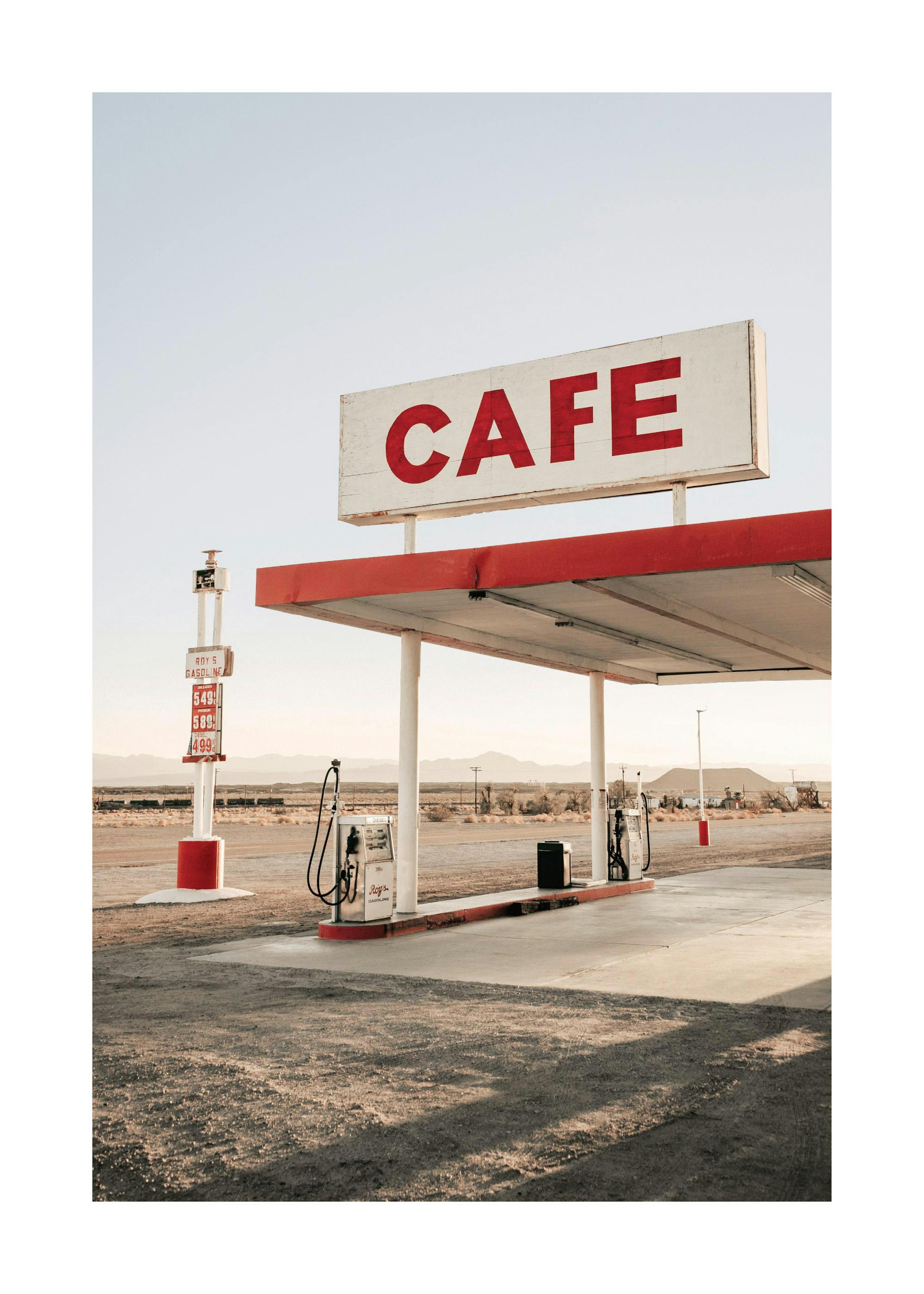 Photography of a gas station and cafe in an open field, with red signs and details, under a clear sky.