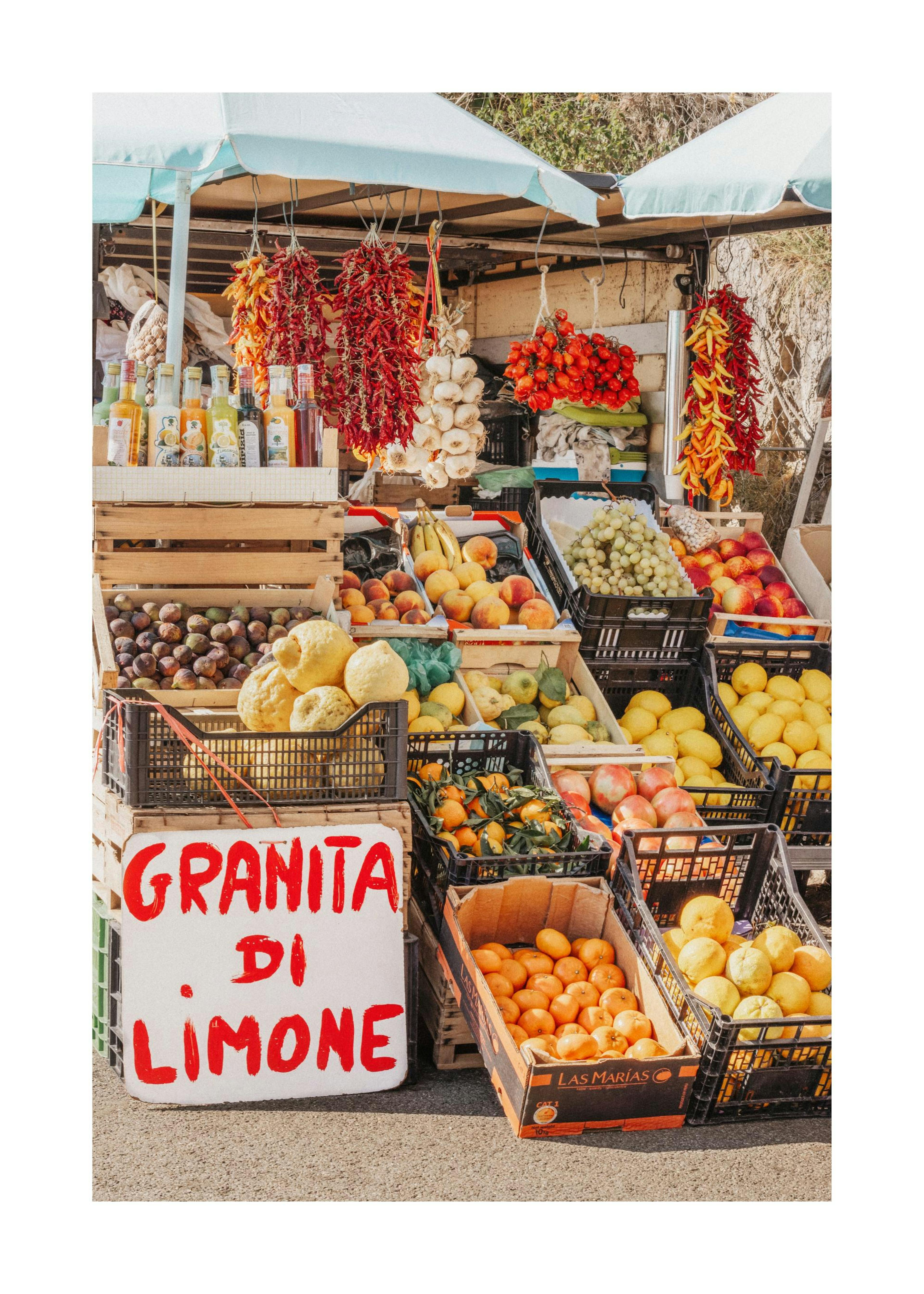 Mercato italiano colorato con frutta fresca, verdure e un cartello Granita di Limone, stile Costiera Amalfitana.