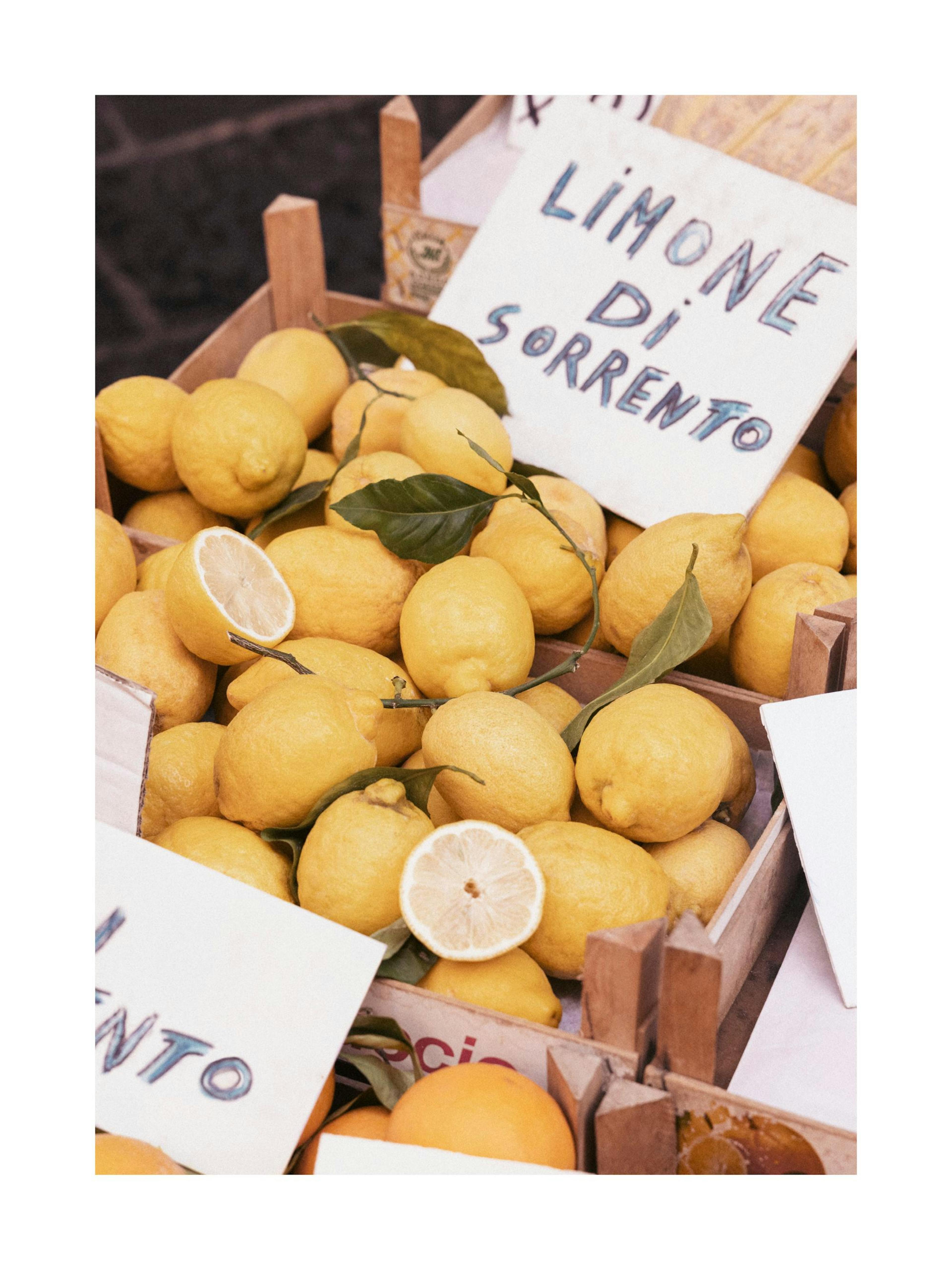 Plakát s detailním záběrem na sorrentské citrony v dřevěné bedně s nápisem Limone di Sorrento.